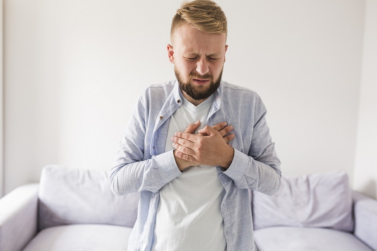 Man holding his chest with heartburn